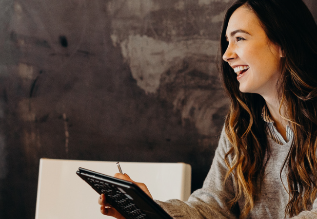 A smiling woman with a tablet computer