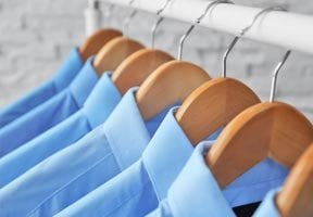 A set of blue shirts hanging on a rail
